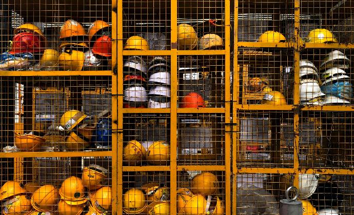 a rack filled with lots of yellow hard hats